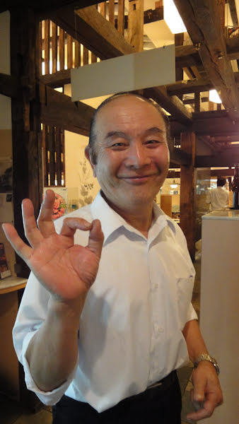the waiter smiles and makes an ok gesture